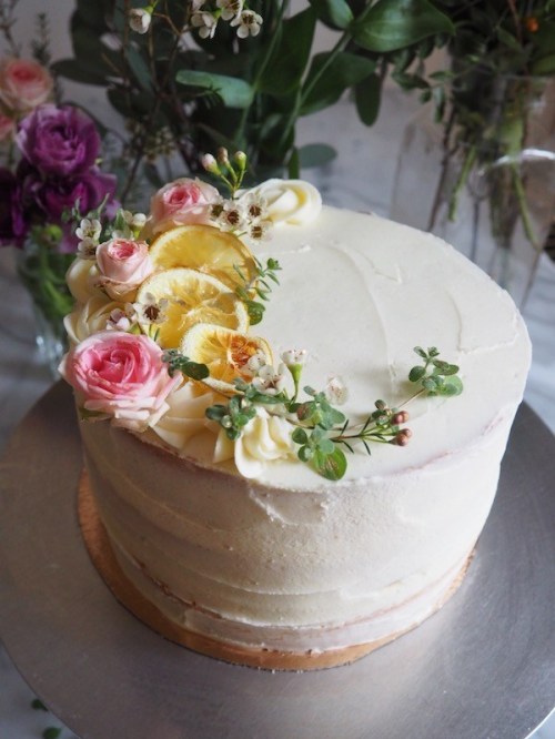 Citrus cake with vanilla icing and flowers, by Molly Wilkinson